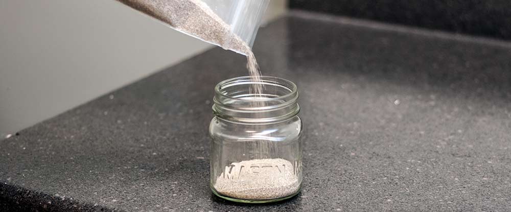 Pouring sand into a mason jar