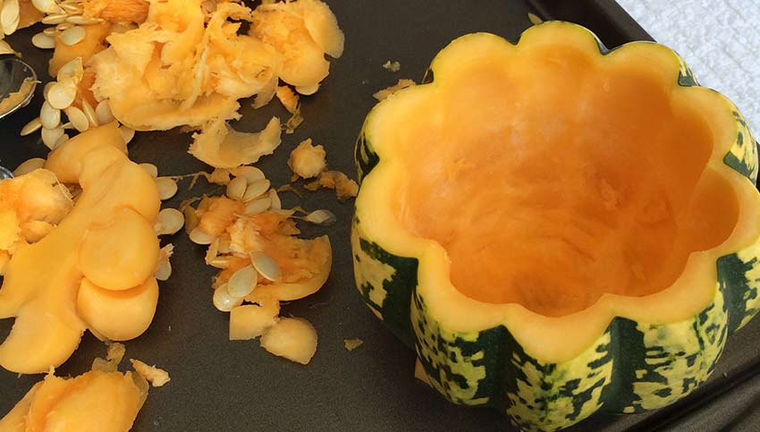 Acorn Squash freshly scooped out with waste piled beside the image