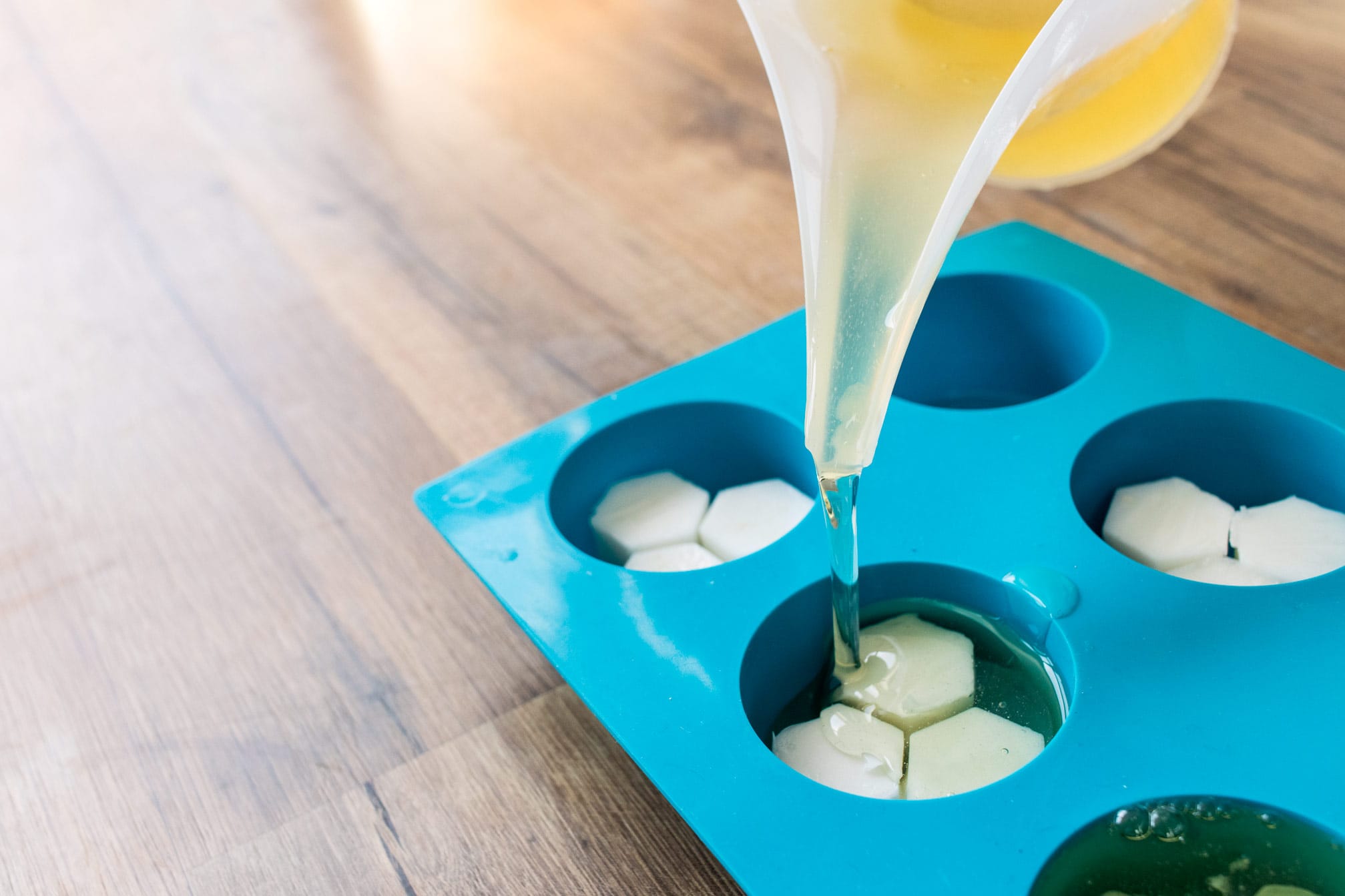 Pouring melt and pour soap base into round silicone mold