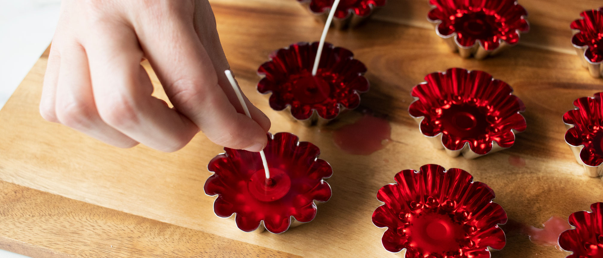 Adding wicks to tart mold candles.