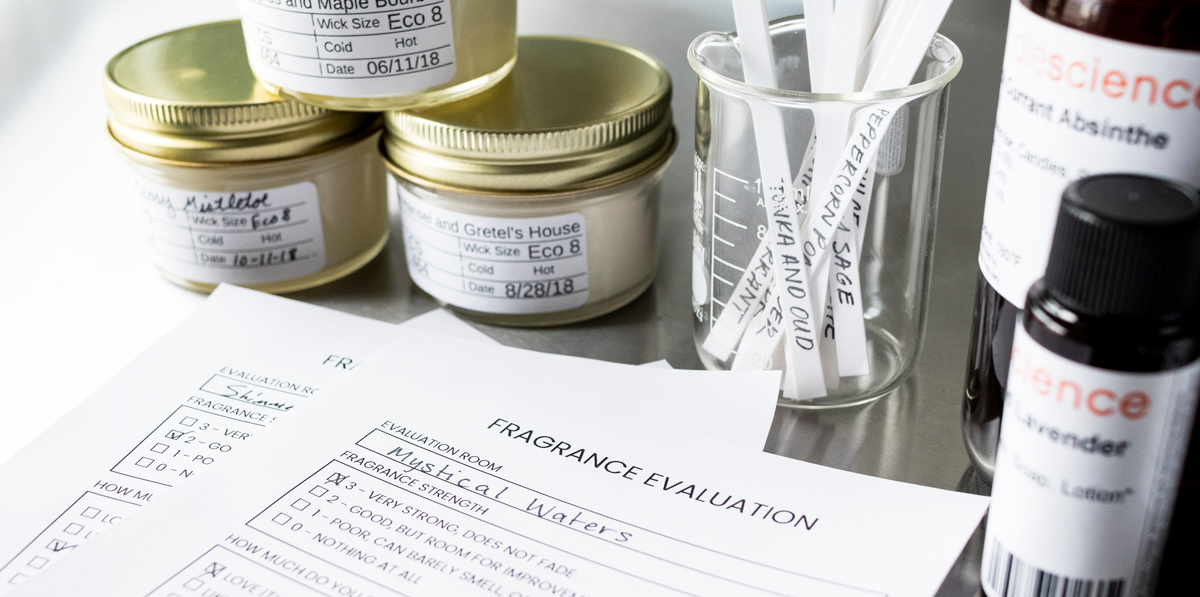 Paperwork, labeled candles, and bottles of fragrance oil