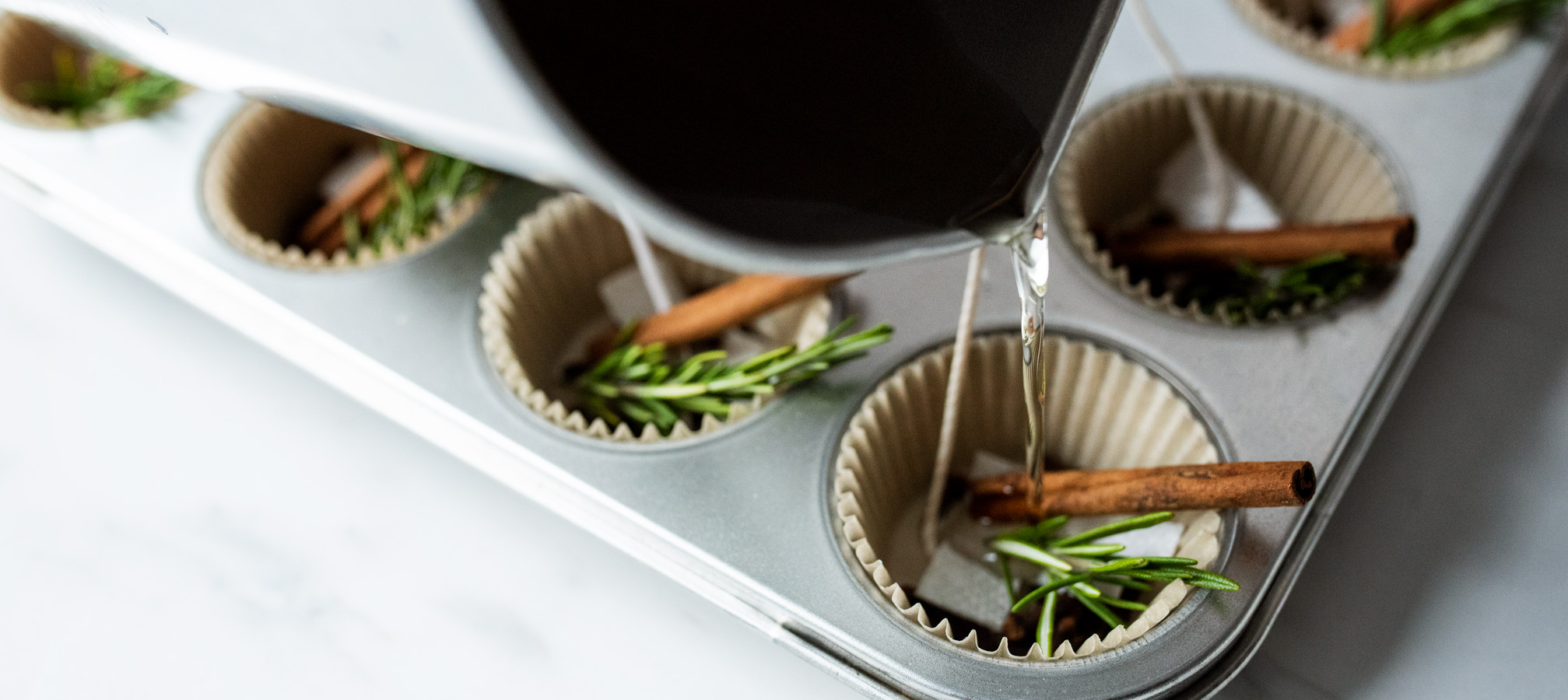 Pouring wax into muffin tin with fire starter filling