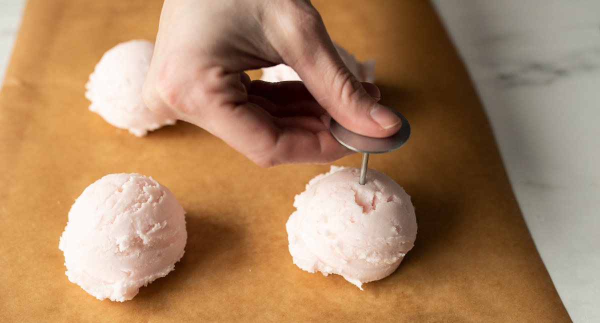 Poking holes in wax ice cream scoops.