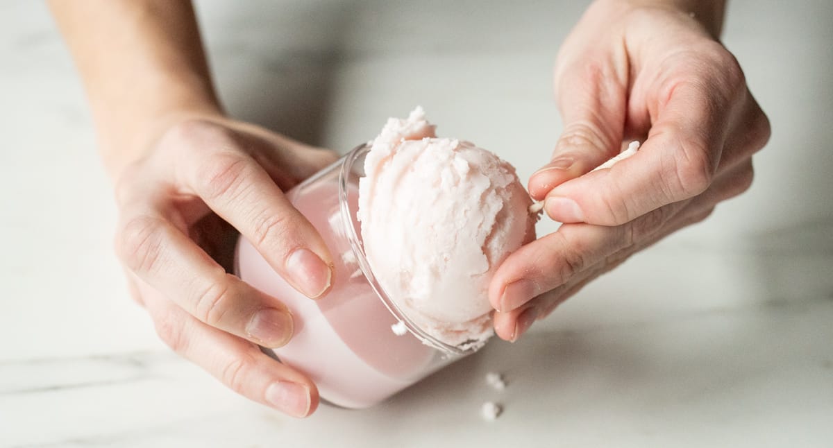 Putting soy wax ice cream scoop onto mini tumbler candle