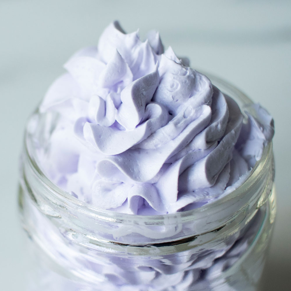 Close up of purple whipped bath soap in a jar.