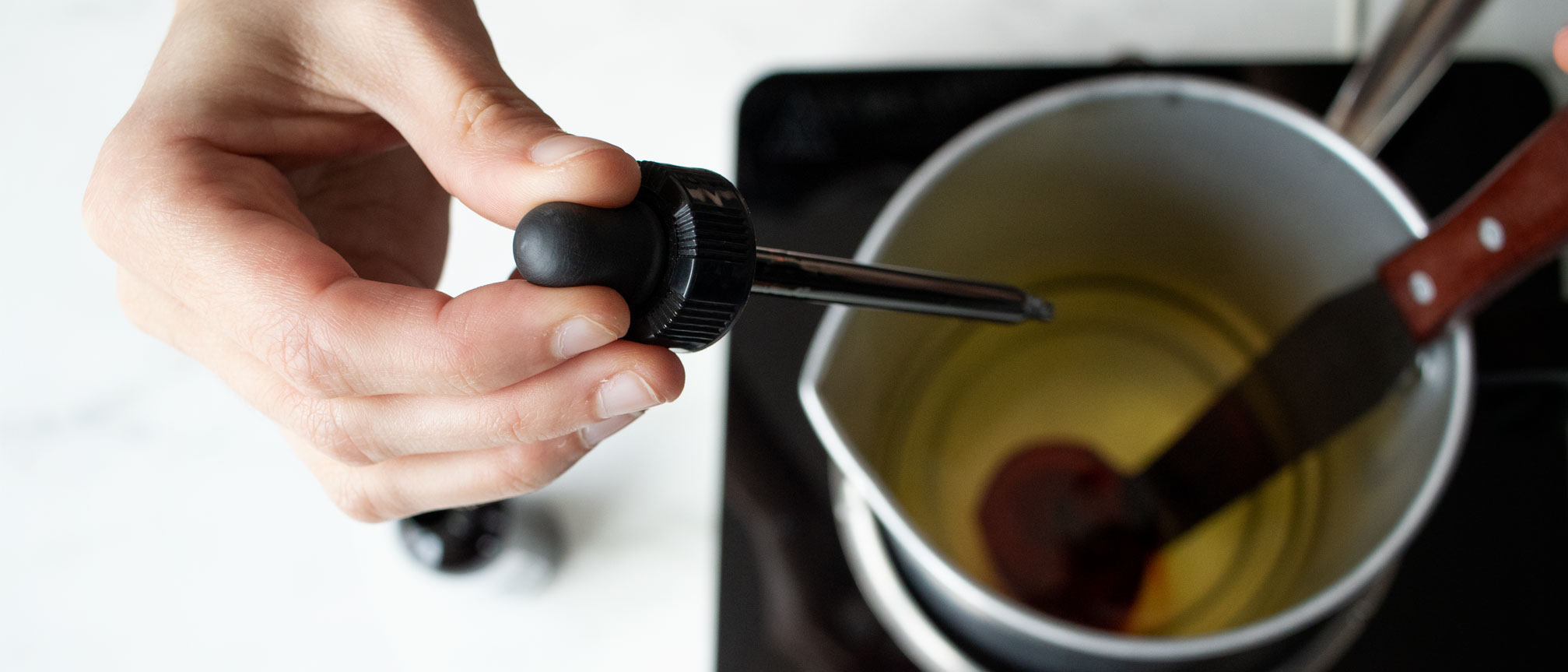 Adding brown liquid candle dye to melted soy way.