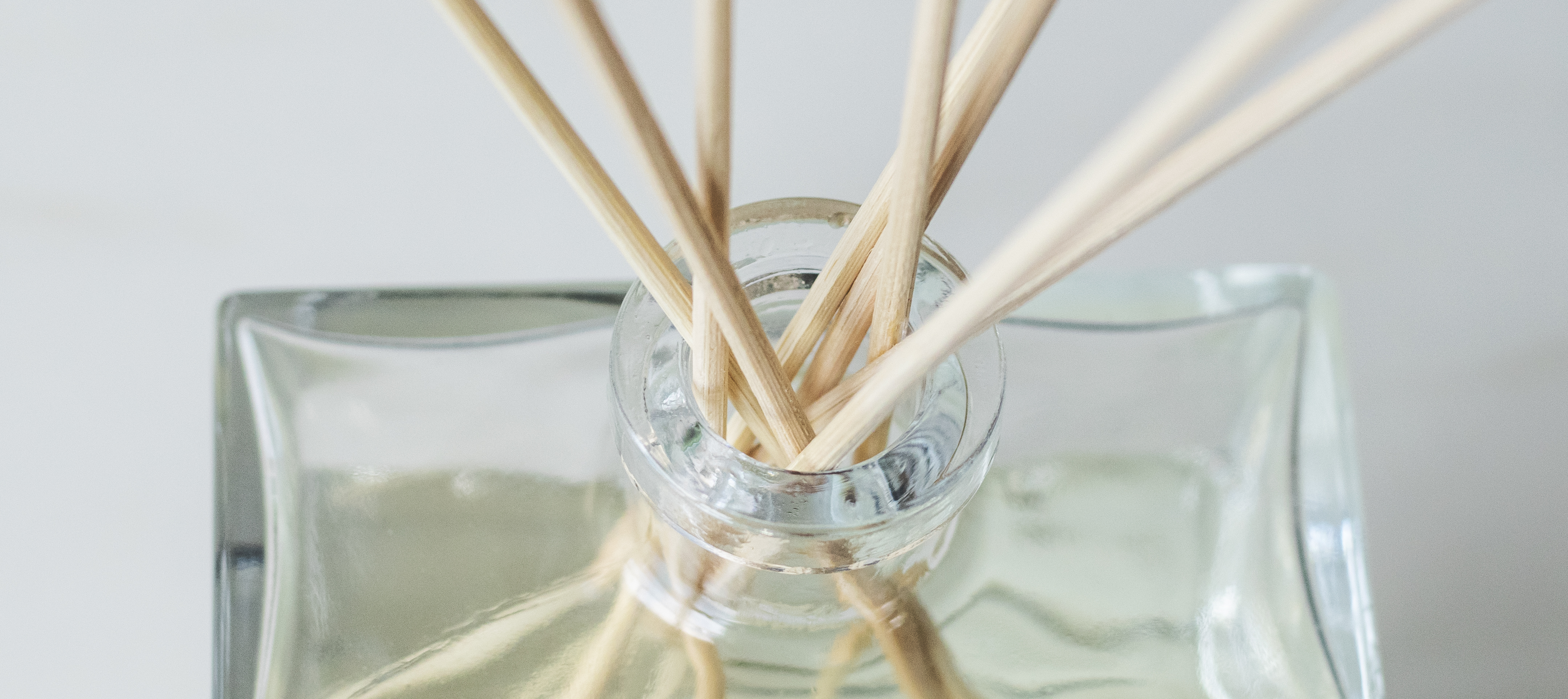 Closeup of a reed diffuser in a glass container.