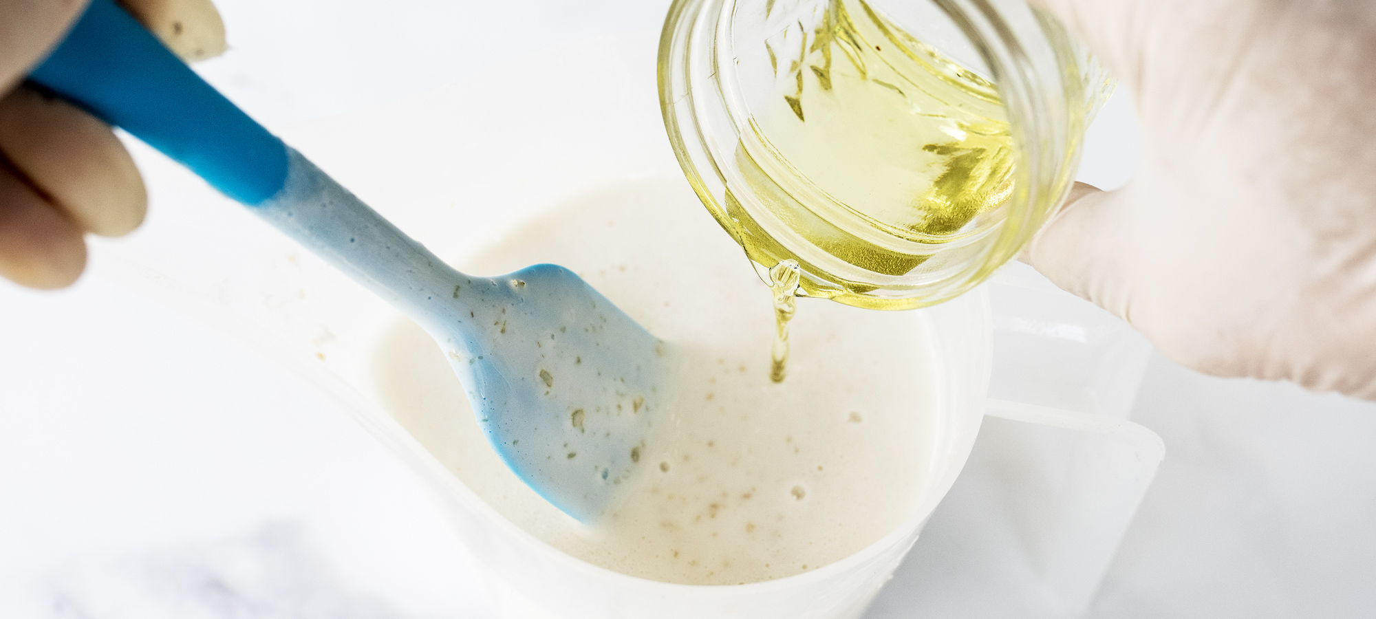 Adding fragrance oil to oatmeal shea soap base.