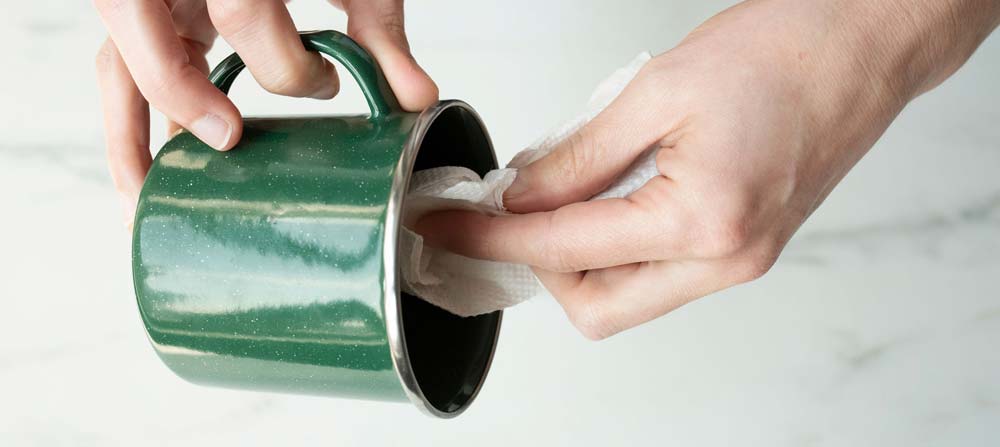 Cleaning out enamel camping mug to prepare for candle making