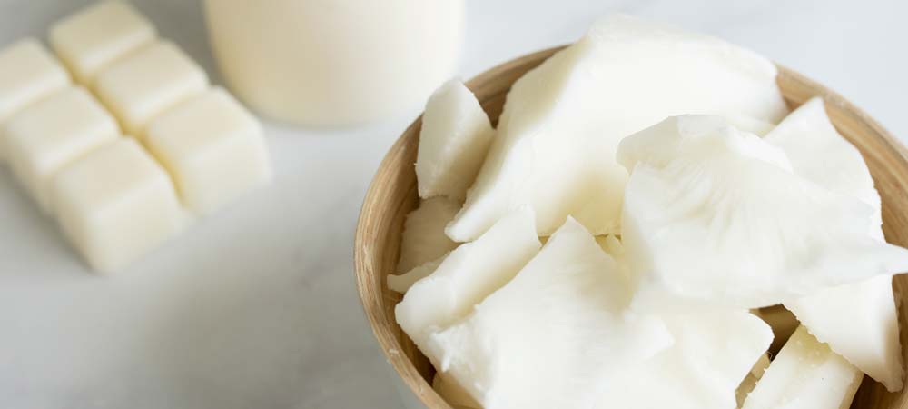 IG-6028 paraffin soy pillar wax notes header Bowl of wax next to blocked wax on the table.