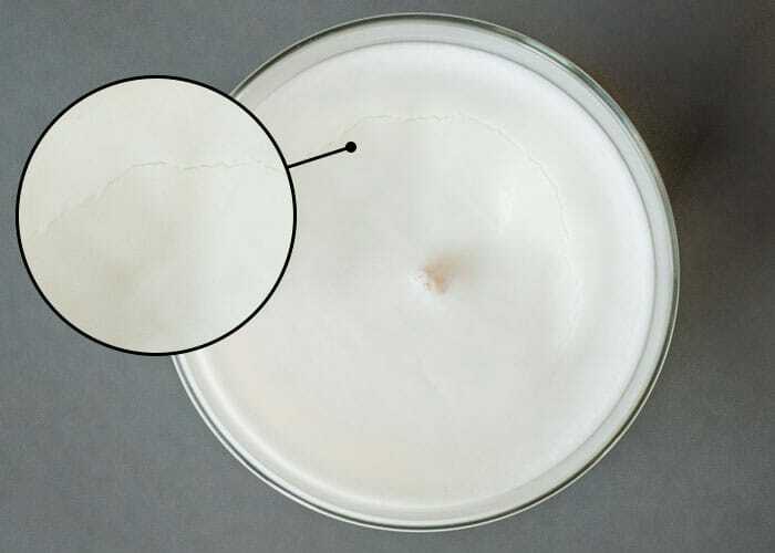 Soy wax candle with a crack circling around the wick. 