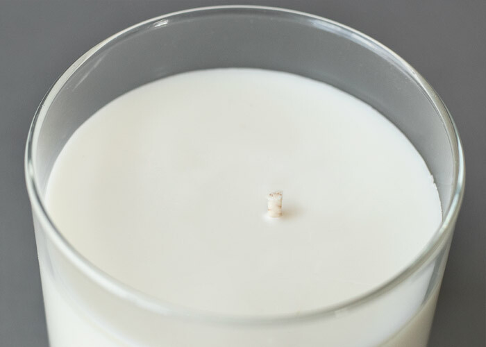 Soy wax candle with wick sitting off of the center of the candle. 