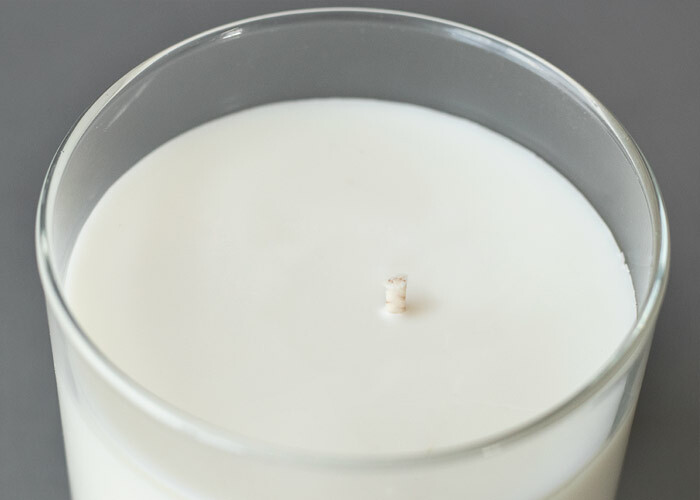 Soy candle with an off centered wick.