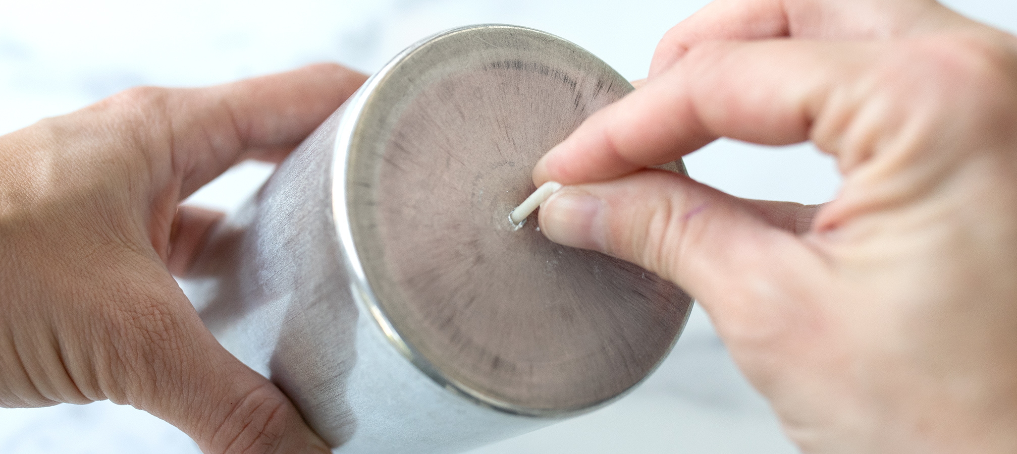 Threading a wick through a pillar mold.