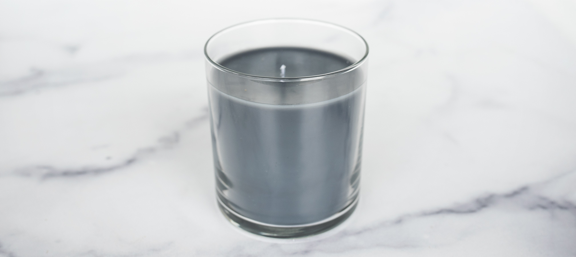 Close up of glass adhesion on a clear straight sided tumbler container candle.