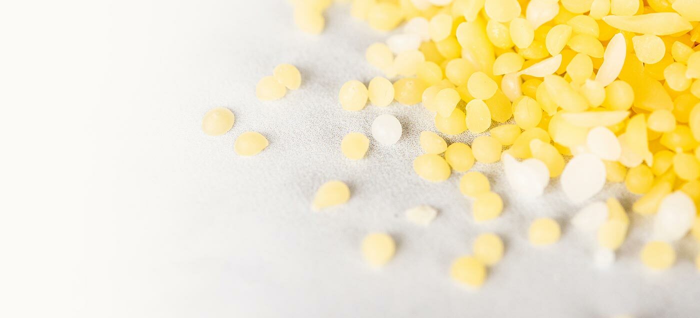 Closeup of yellow and white beeswax pastilles.