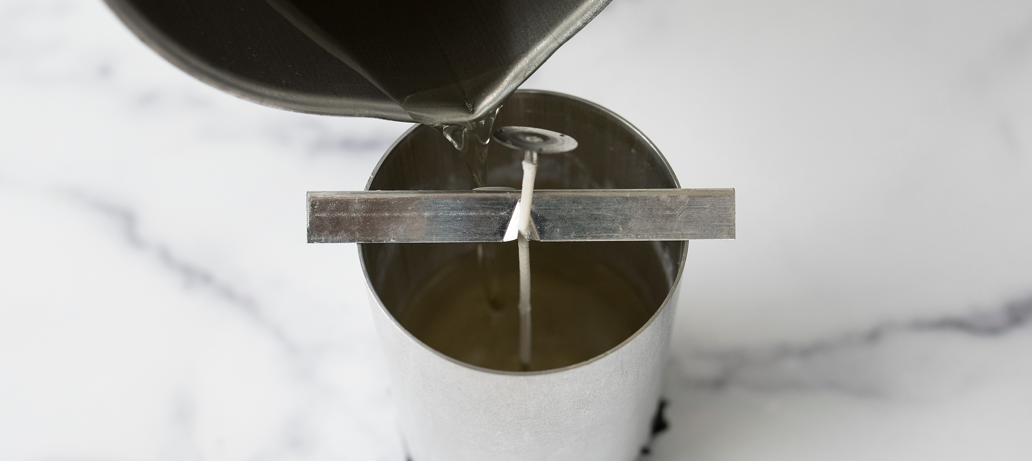 Pouring melted wax into a pillar mold.