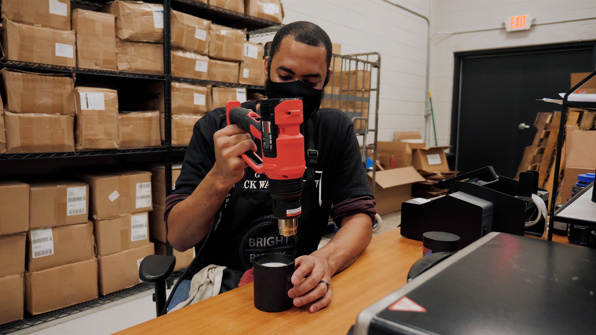 Dariel from Bright Black holding a heat gun above a candle.