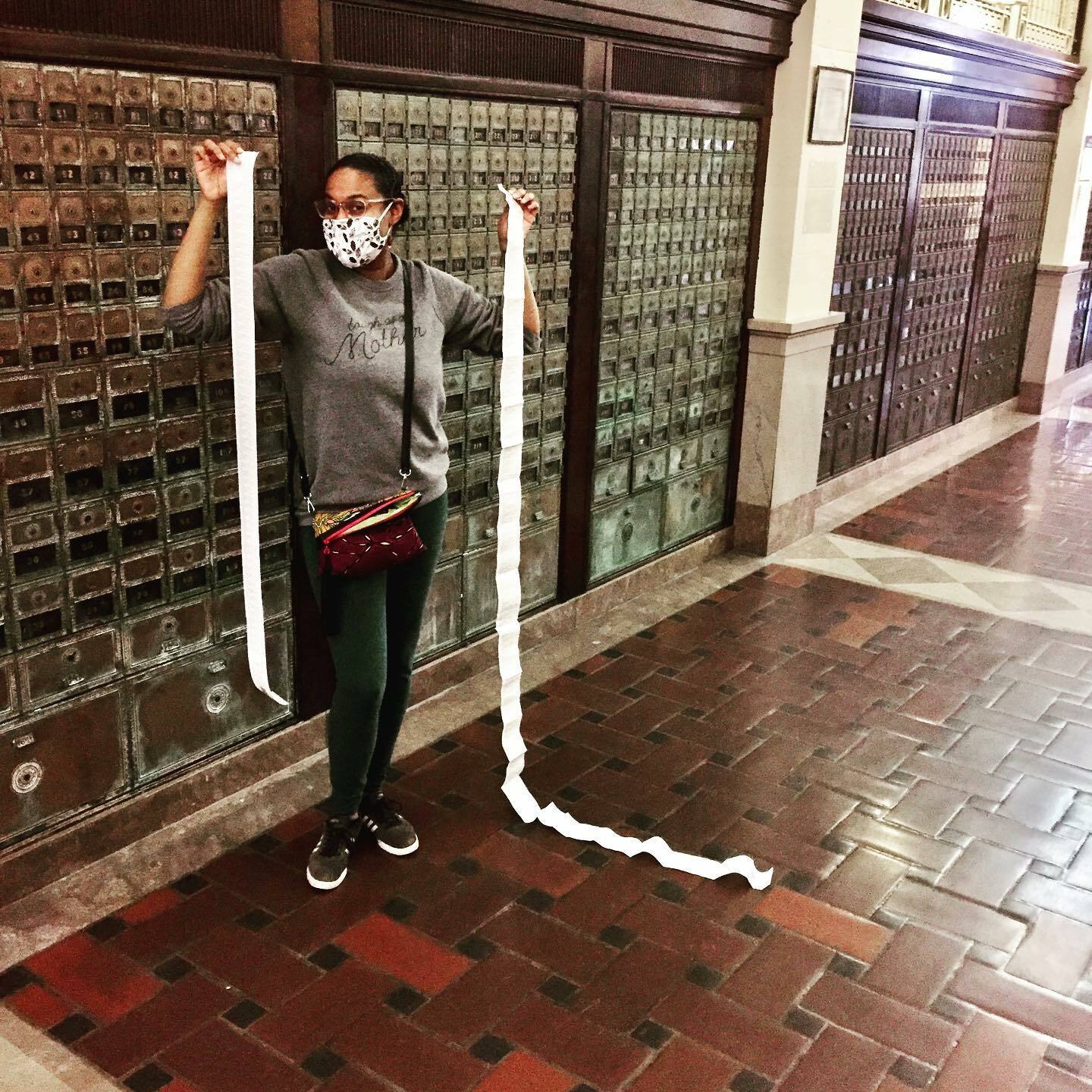 A woman excitedly holding up two long sheets of shipping labels.