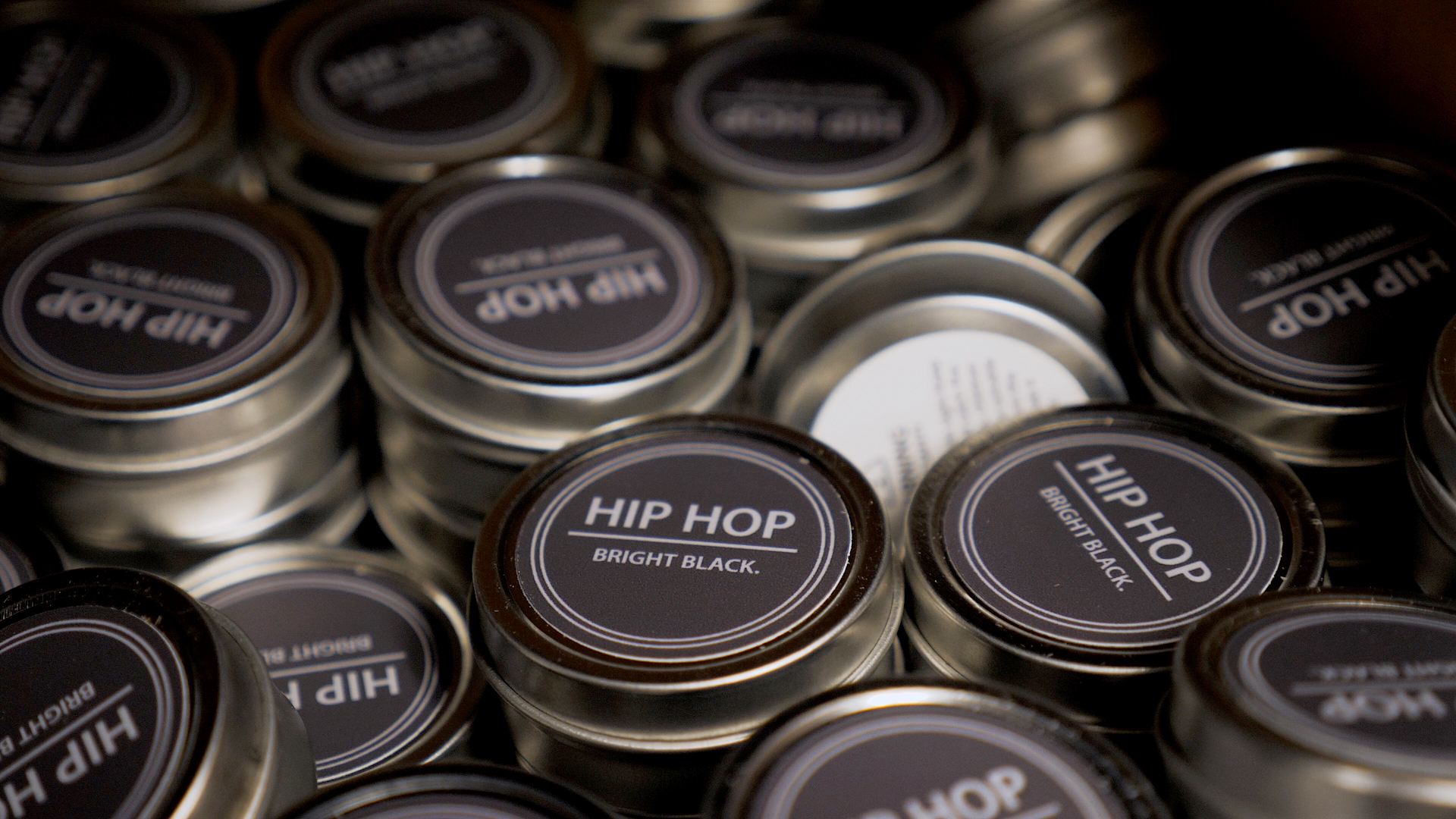 A bunch of candle tins with a label that says Hip Hop.