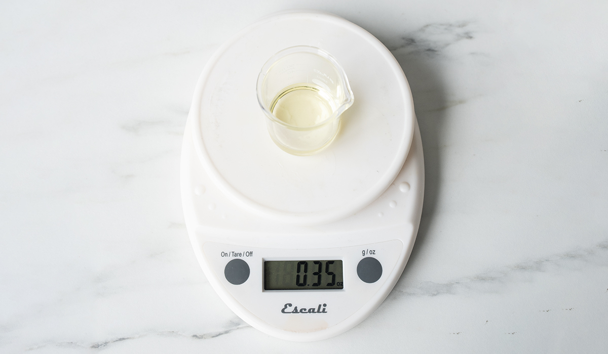 Weighing fragrance oil on a digital scale.