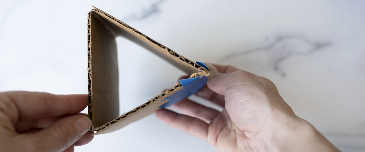 Cardboard folded into a triangle held together by tape.