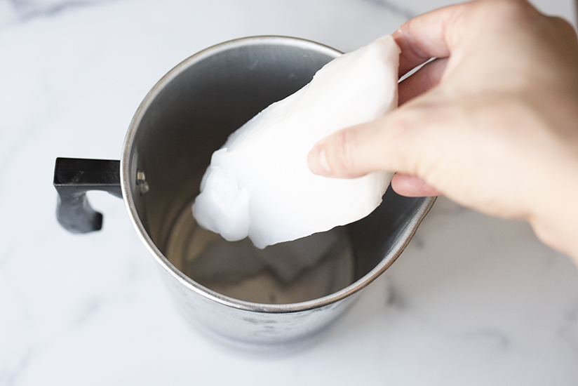 Adding wax to a pouring pitcher.