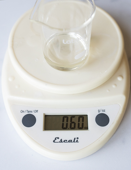 Weighing fragrance oil on a digital scale.