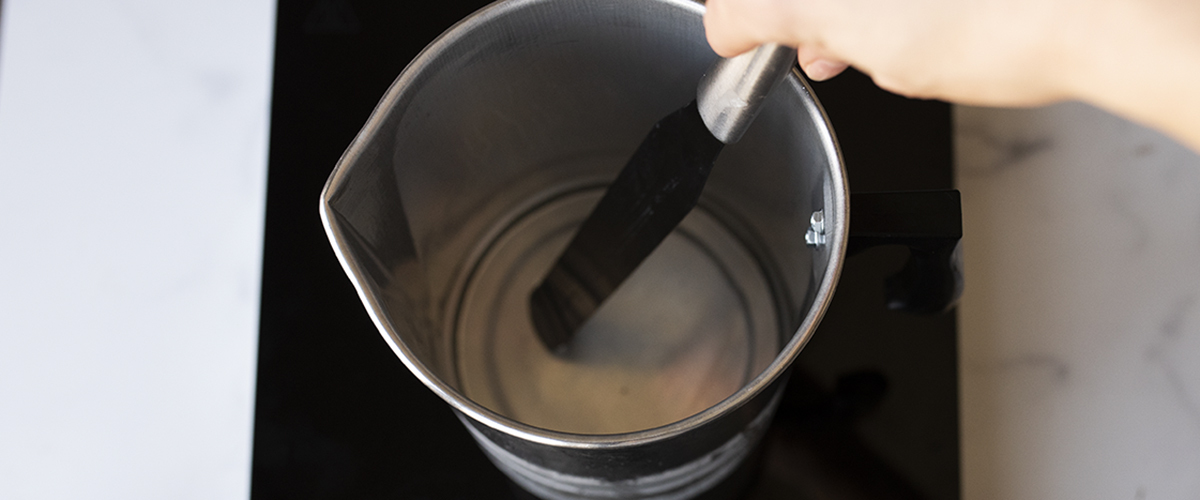 Stirring fragrance oil into melted wax.