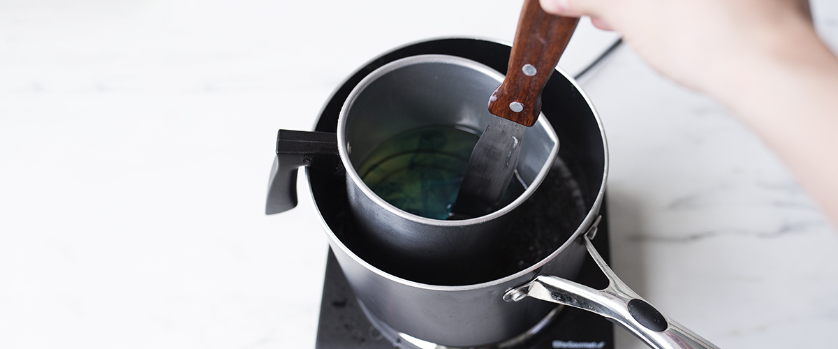 Stirring dye in melted wax.