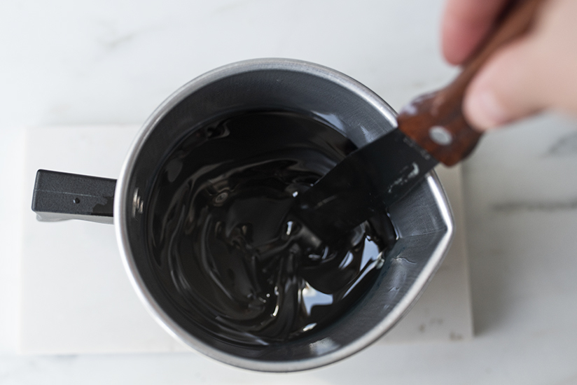 Stirring fragrance oil into melted soy wax.