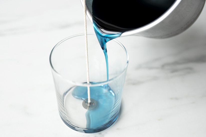 Pouring melted wax into tumbler jar.