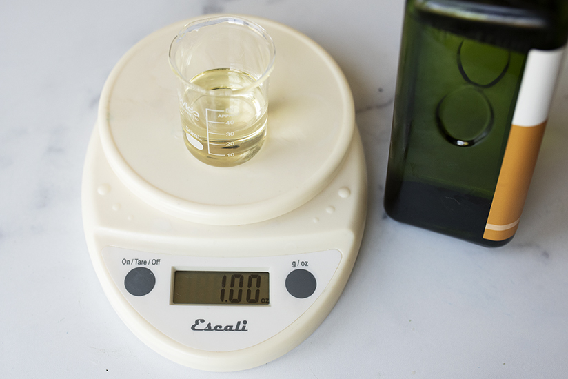 Pouring sunflower oil into a beaker on a scale.