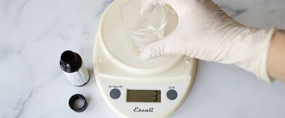 Weighing fragrance oil on a digital scale.