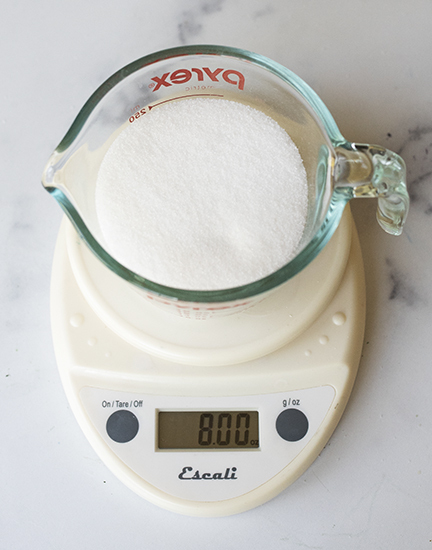 Weighing sugar on a digital scale.
