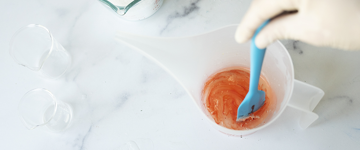 Stirring liquid soap dye into melt and pour soap.