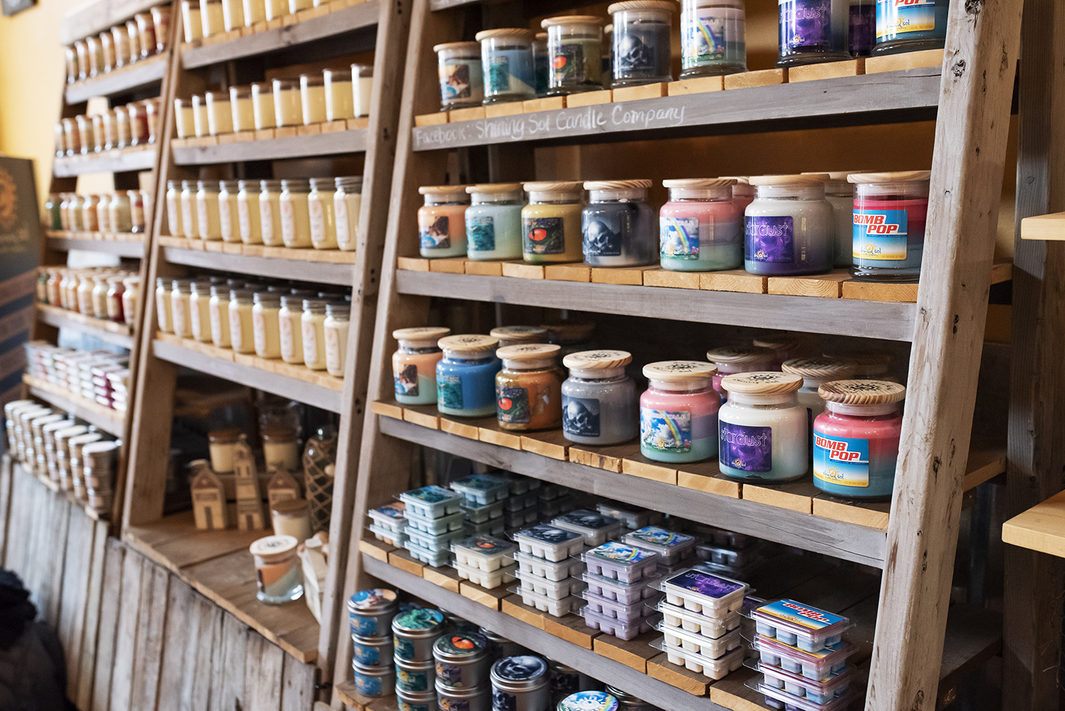 Candles lined up on a shelf.