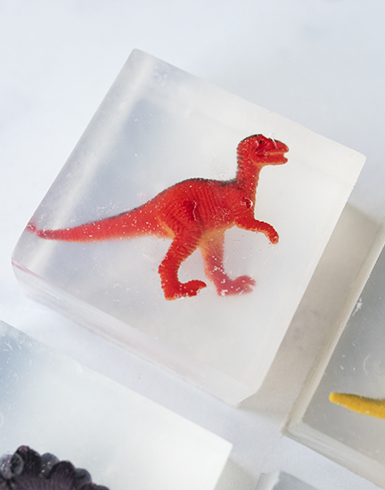 Toy dinosaur in a clear soap bar.