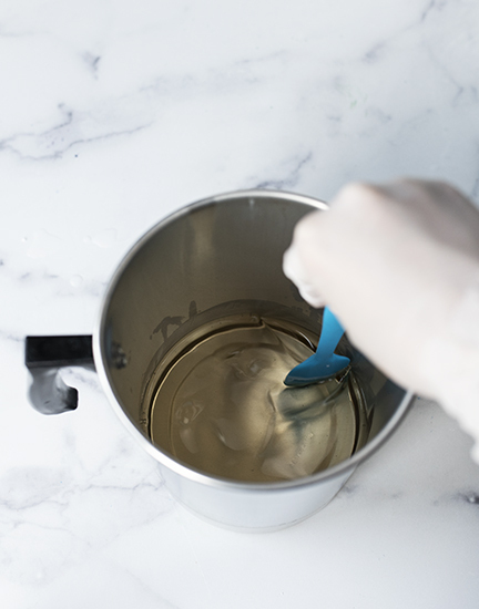 Stirring melted cosmetic base with a silicone spatula.
