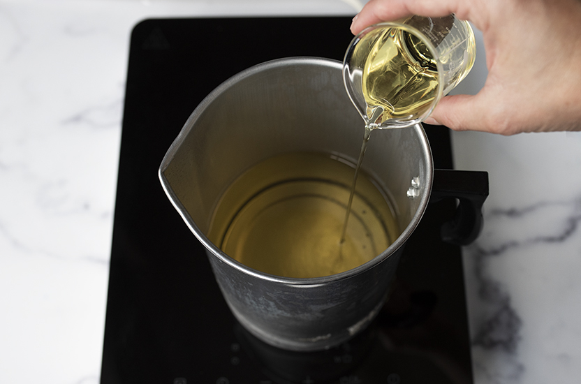 Adding fragrance oil to melted soy wax.