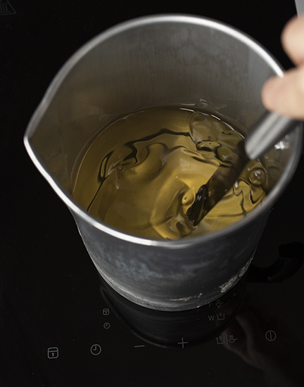 Stirring fragrance oil into melted soy wax.