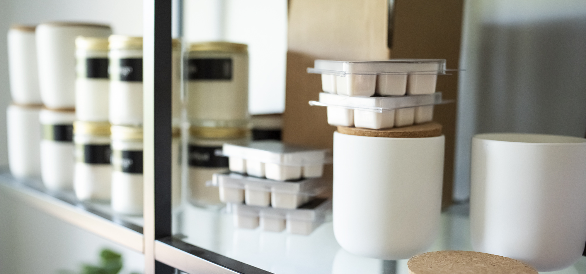 Candles and wax melts stacked on a shelf.