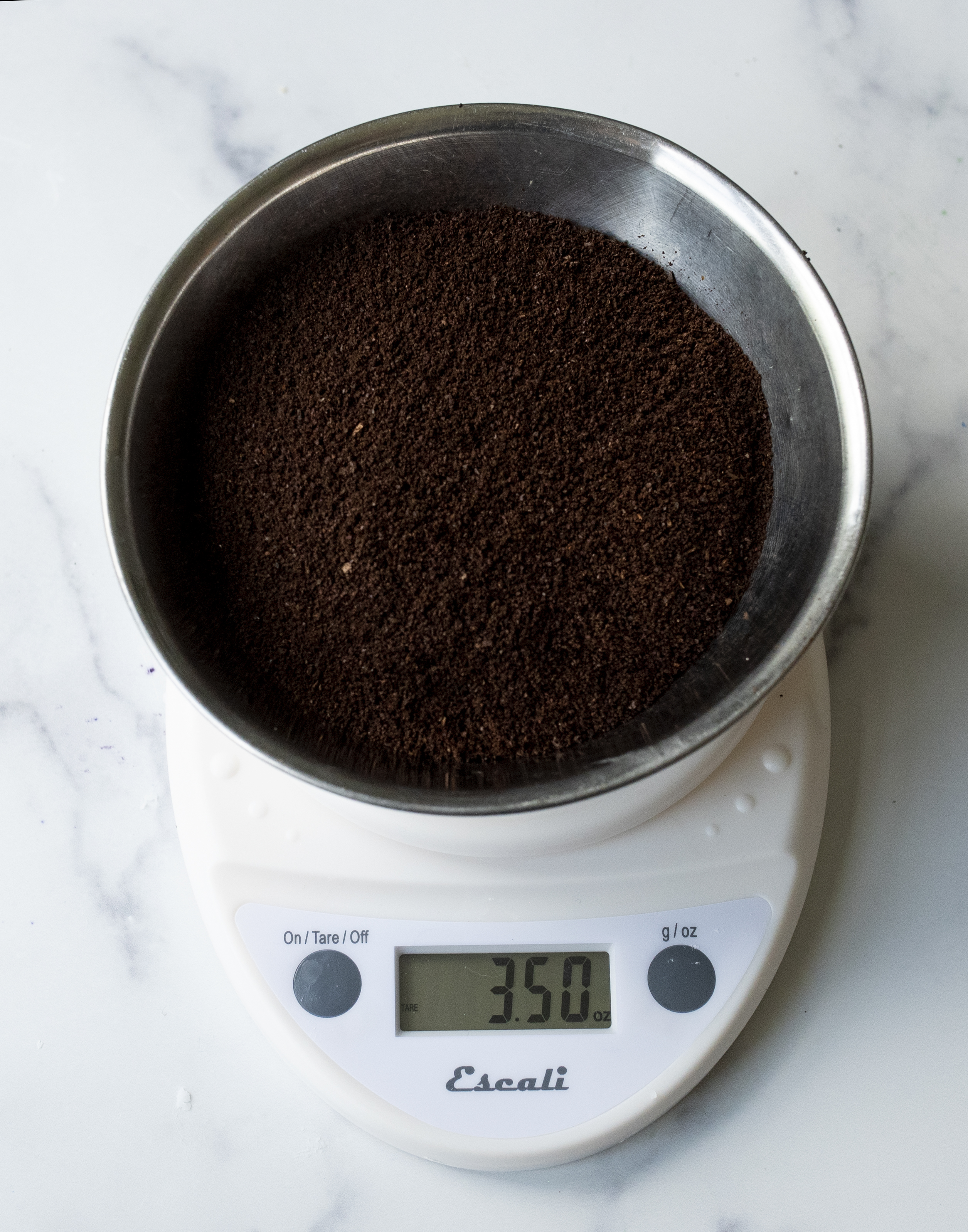 Weighing ground coffee on digital scale.