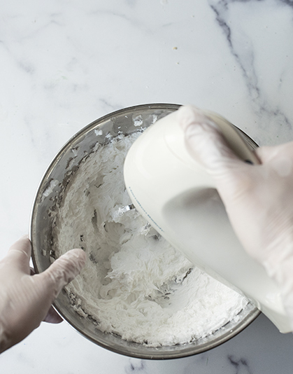 Mixing foaming bath butter base in a bowl.