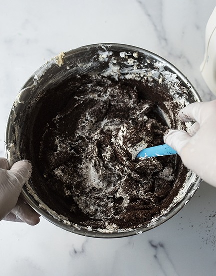 Mixing in coffee to scrub with a silicone spatula.