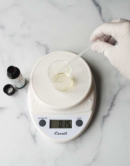 Weighing fragrance oil on a digital scale.