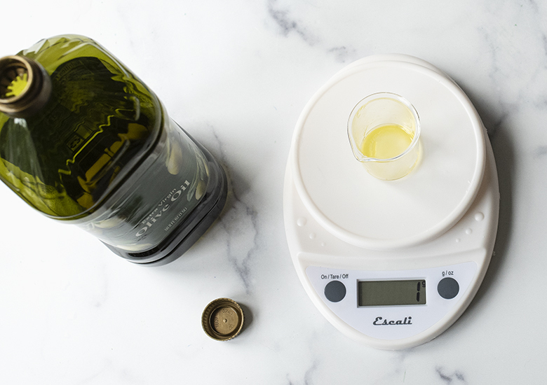 Weighing olive oil on a scale.
