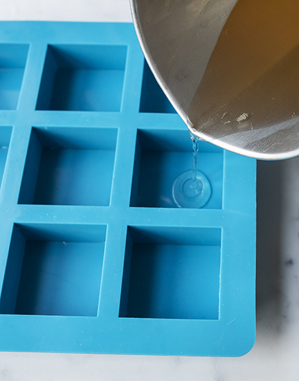 Pouring melted base into silicone soap mold.