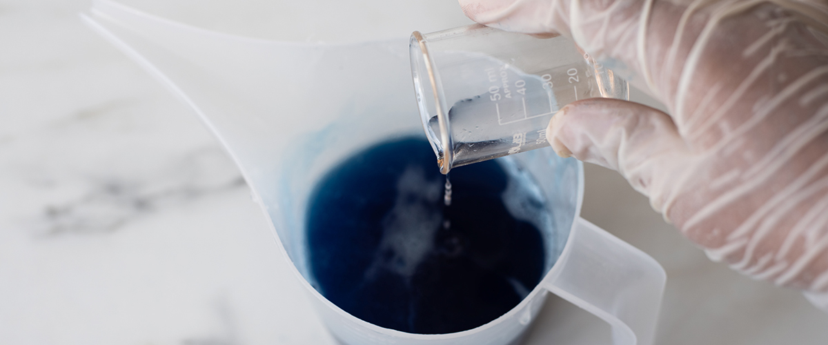 Pouring fragrance oil into melted soap base.