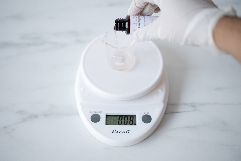 Weighing fragrance oil on a digital scale.